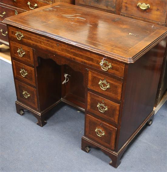 A George II style walnut & feather banded kneehole desk, W.92cm